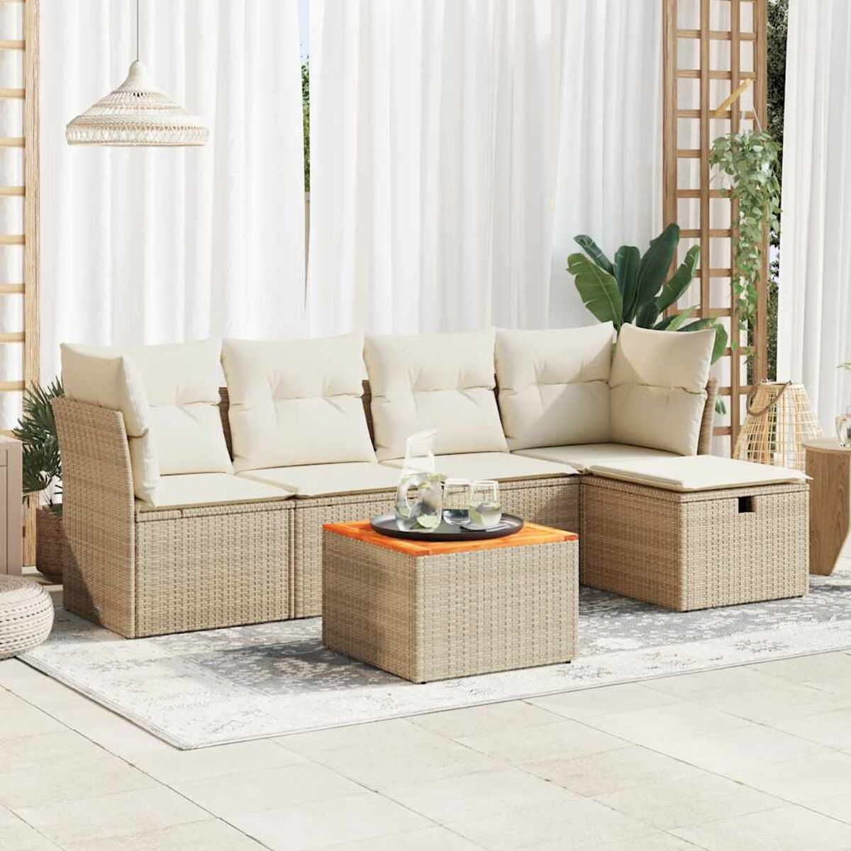 Ein hellbraunes Outdoor-Sitzset aus Korbgeflecht mit Kissen und kleinem Tisch.