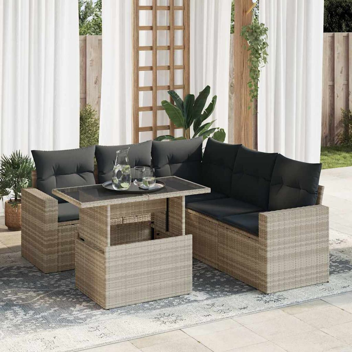 Wicker-Terrassenset mit Tisch und Sofa mit schwarzen Kissen, Glas und Wasserkrug.