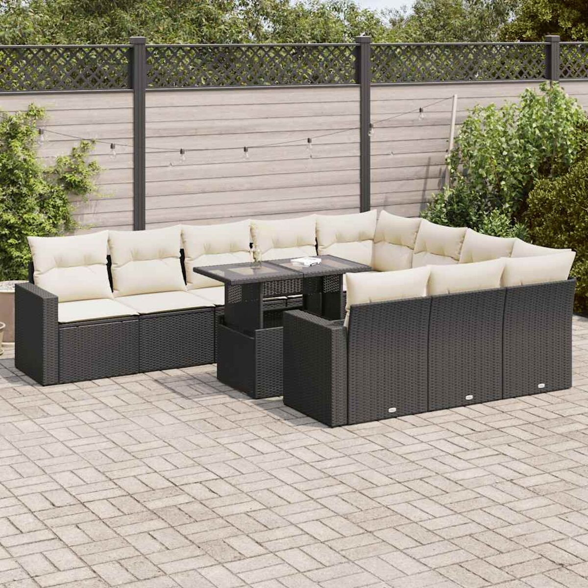Un set patio in bianco e nero. C'è un tavolo e un divano componibile con cuscini grigi.