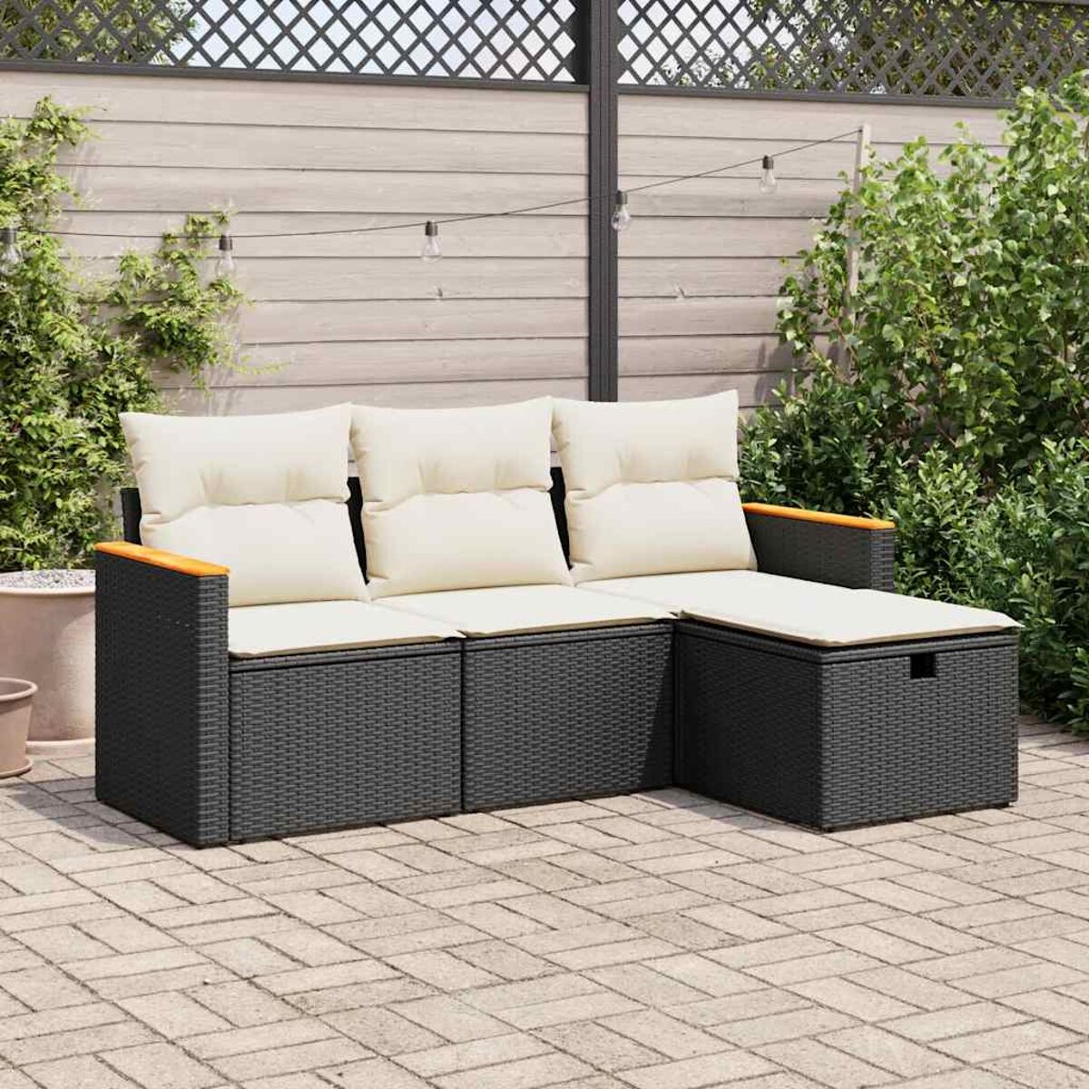 Outdoor-Korbsessel mit weißen Kissen und Holzarmlehnen. Er befindet sich auf einer Ziegelterrasse.