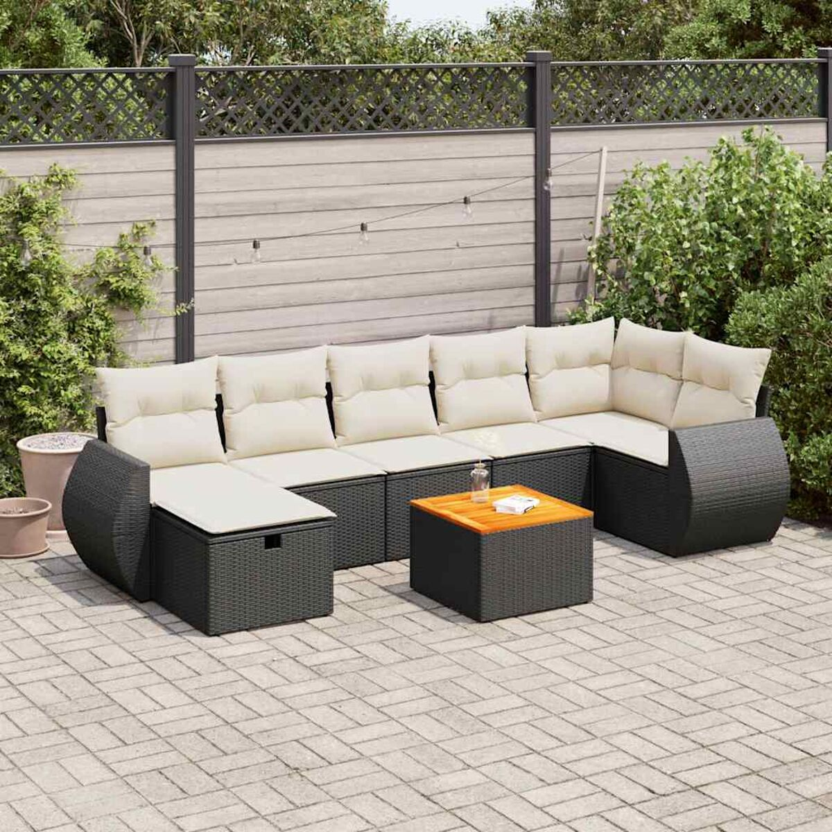 Garten-Eckmöbel: dunkelgraues Rattan mit cremefarbenen Kissen und einem Holztisch.