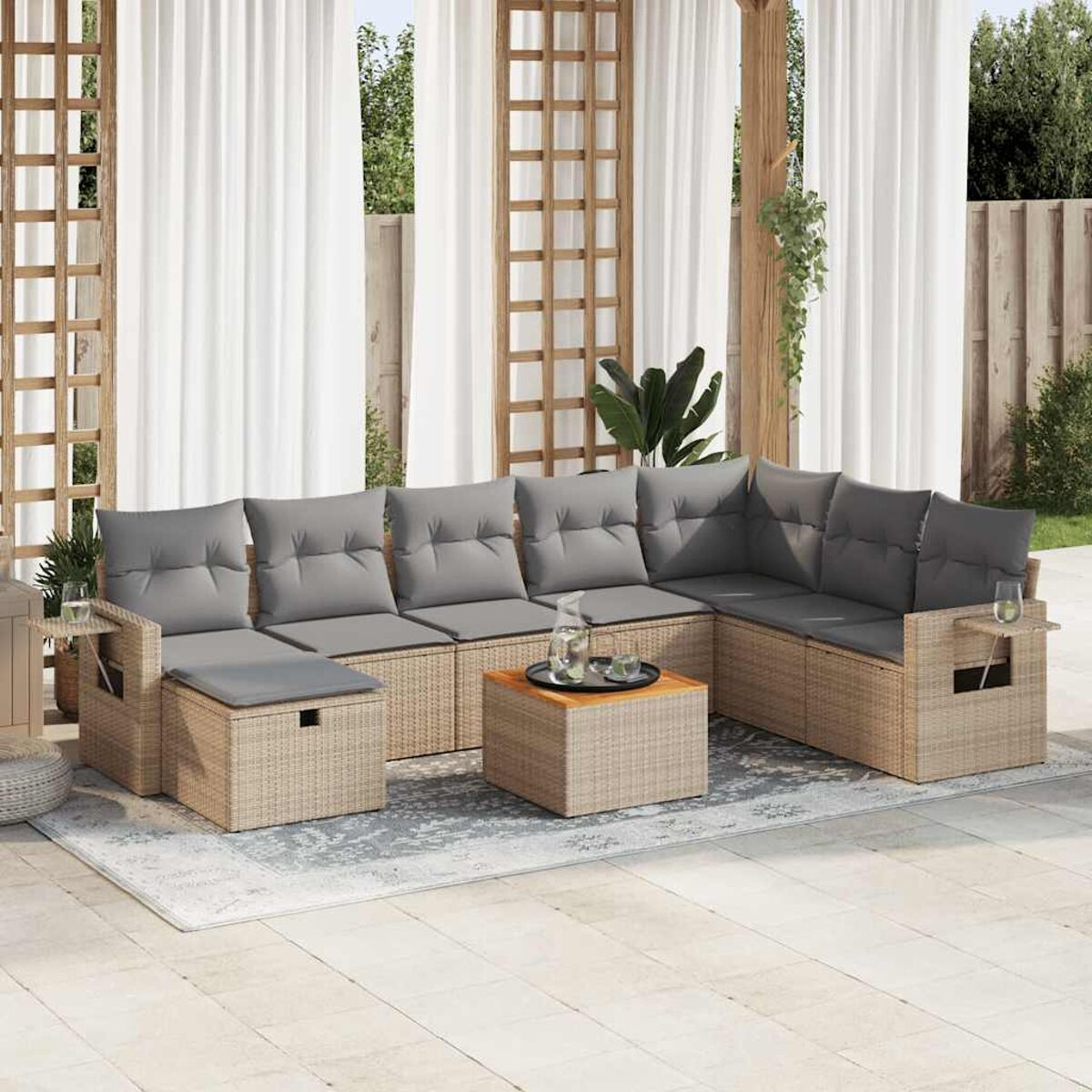 Divano componibile da esterno in rattan beige con cuscini grigi e un tavolo in legno.