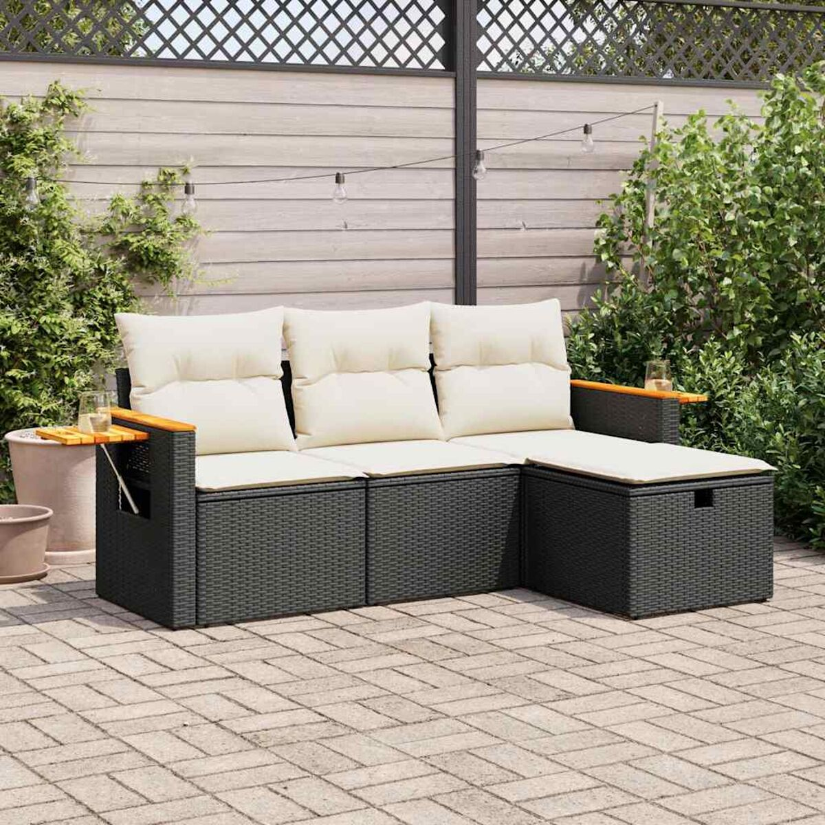 L-förmiges Outdoor-Sofa mit cremefarbenen Kissen. Schwarzer Webrahmen und ein kleiner Tisch. Ziegelterrasse.