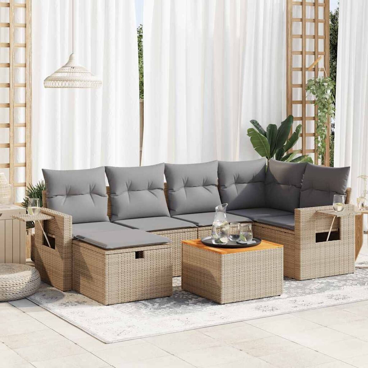 Mobili componibili per esterni: rattan beige con cuscini grigi, tavolino elevabile e bicchieri.