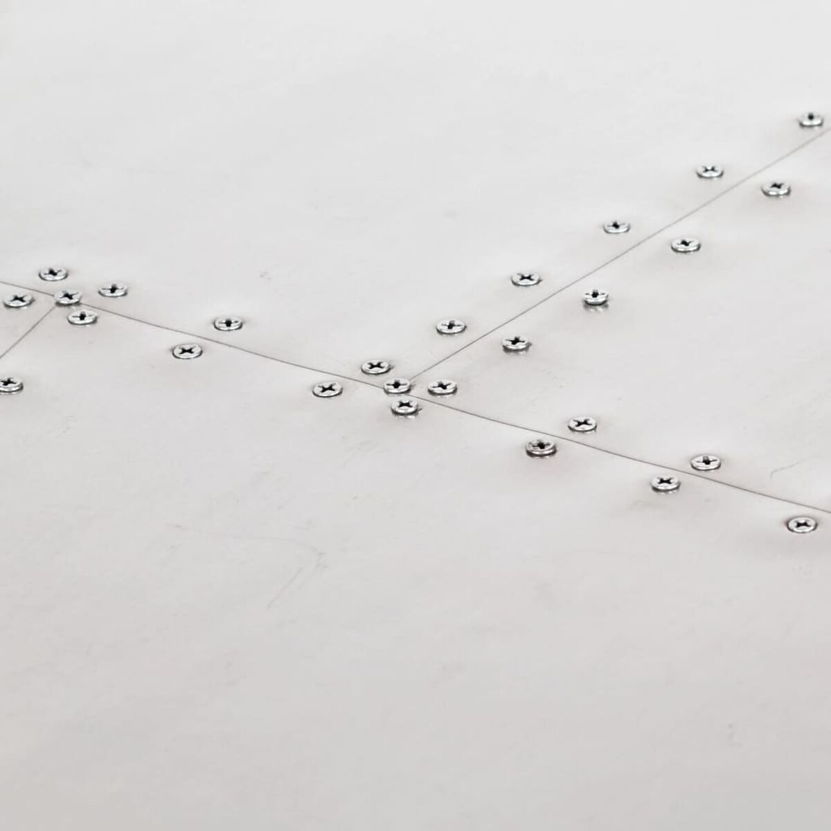 Nahaufnahme einer Metalloberfläche mit Schrauben in einem Muster angeordnet.