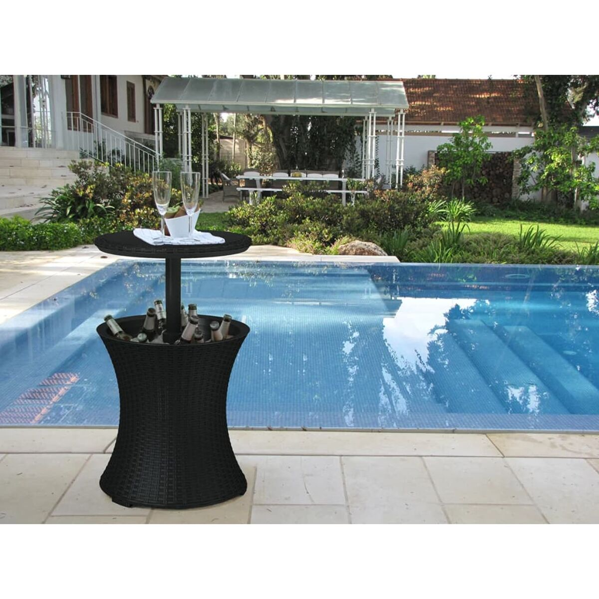 Schwarzer Korbtischkühler mit Getränken am Pool. Pavillon im Hintergrund.