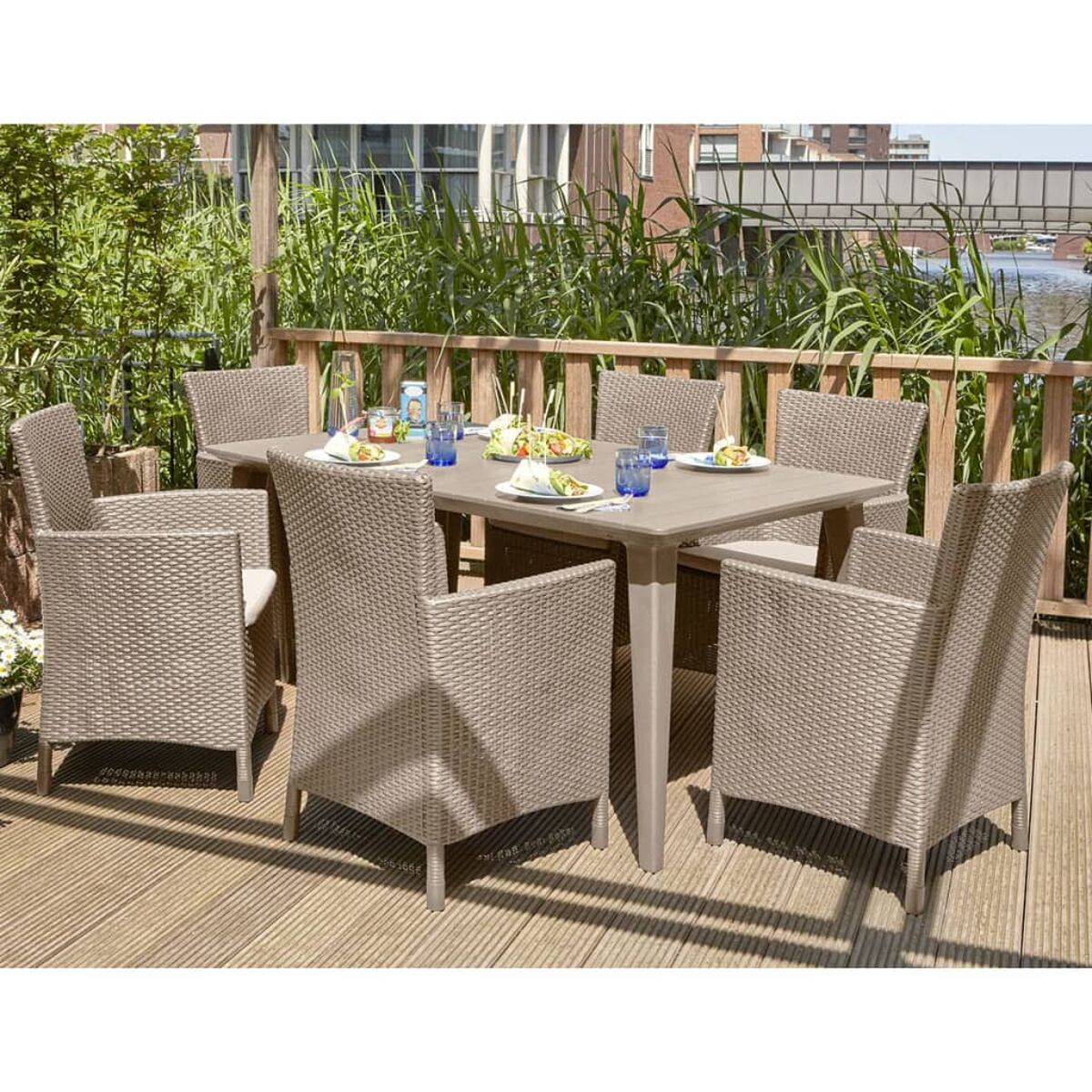 Set da pranzo all'aperto, sei sedie attorno a un tavolo, su una terrazza di legno.