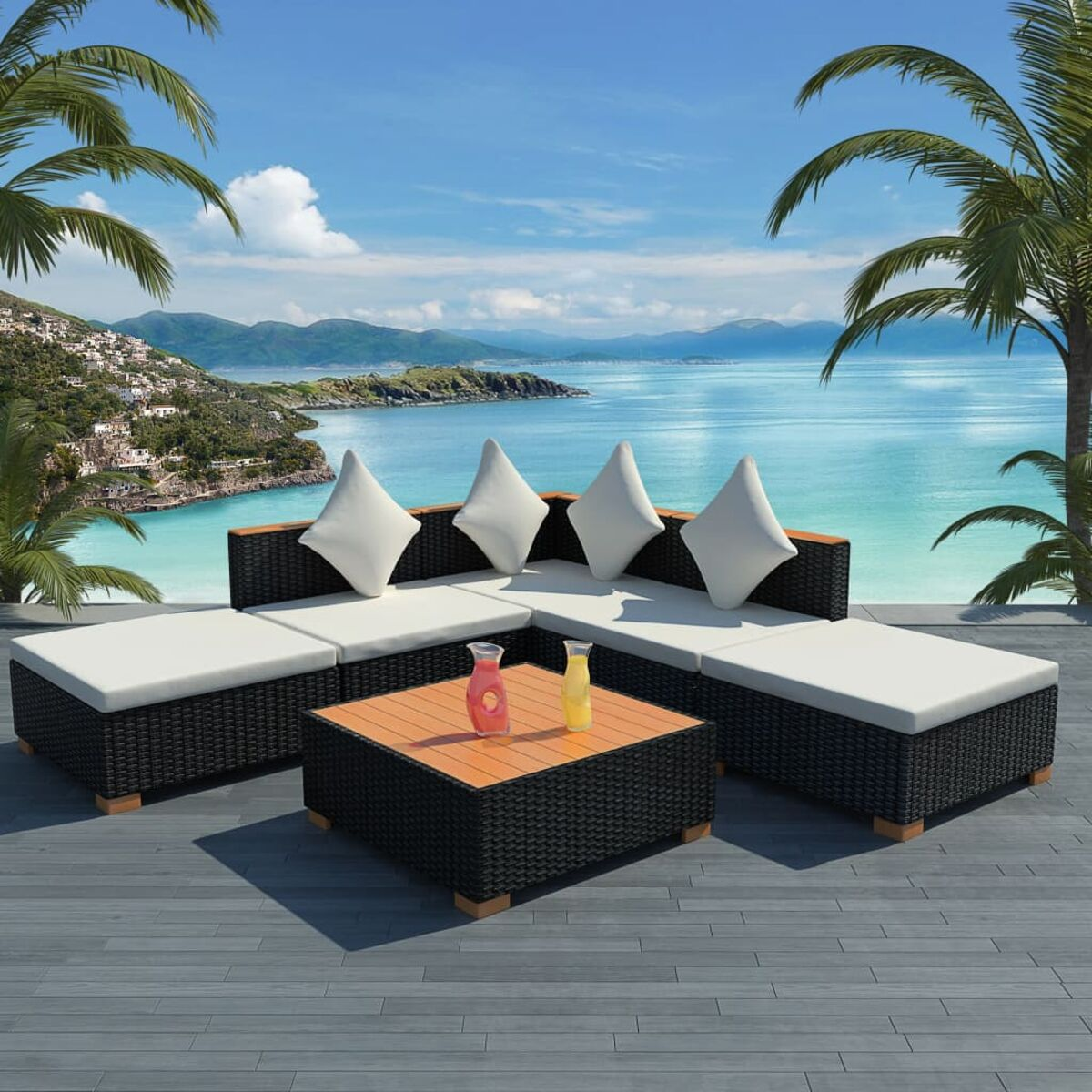 Outdoor-Sofagarnitur mit weißen Kissen und einem Holztisch, am Meer.