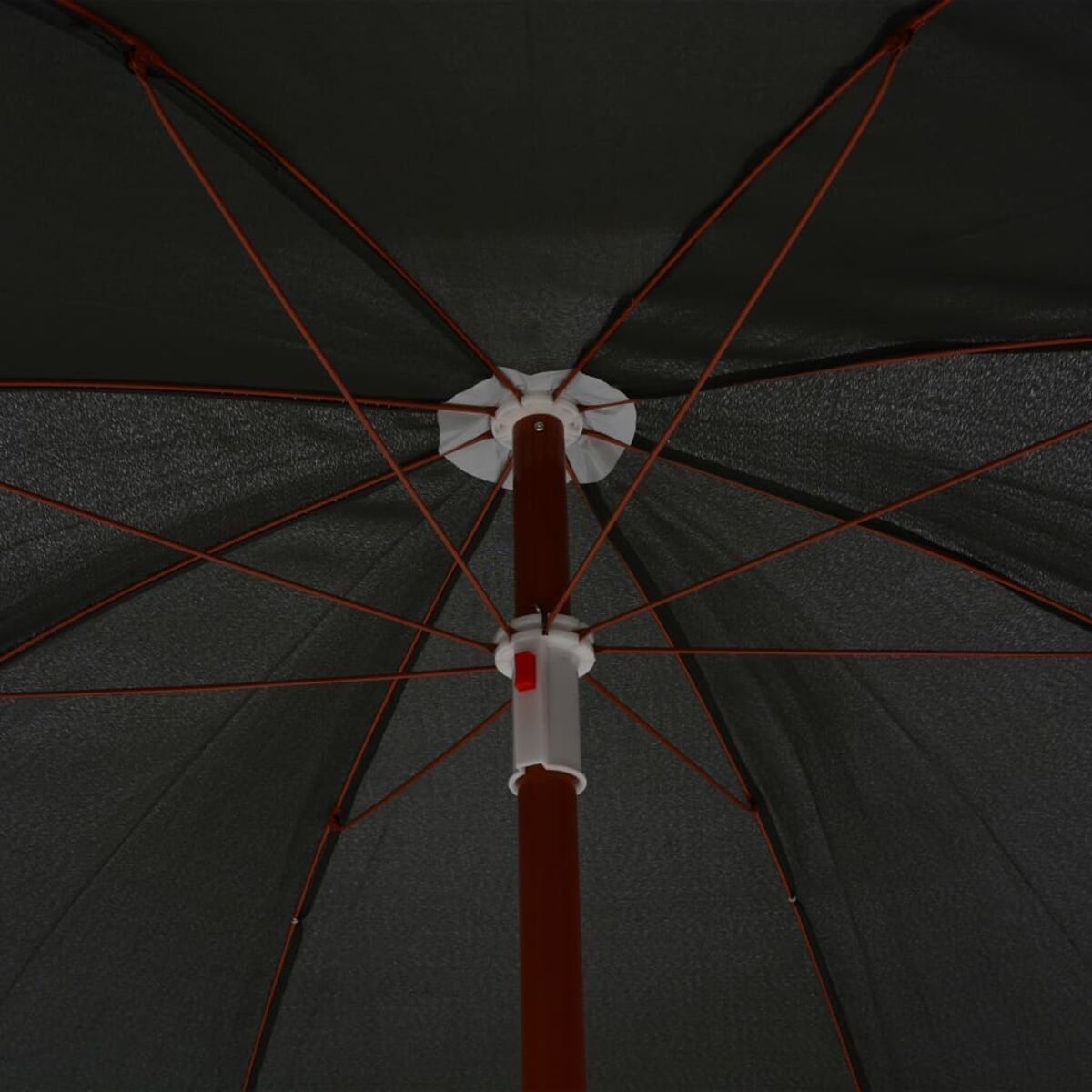 Ansicht von unter einem schwarzen Regenschirm. Rippen und ein roter Knopf in der Mitte sichtbar.