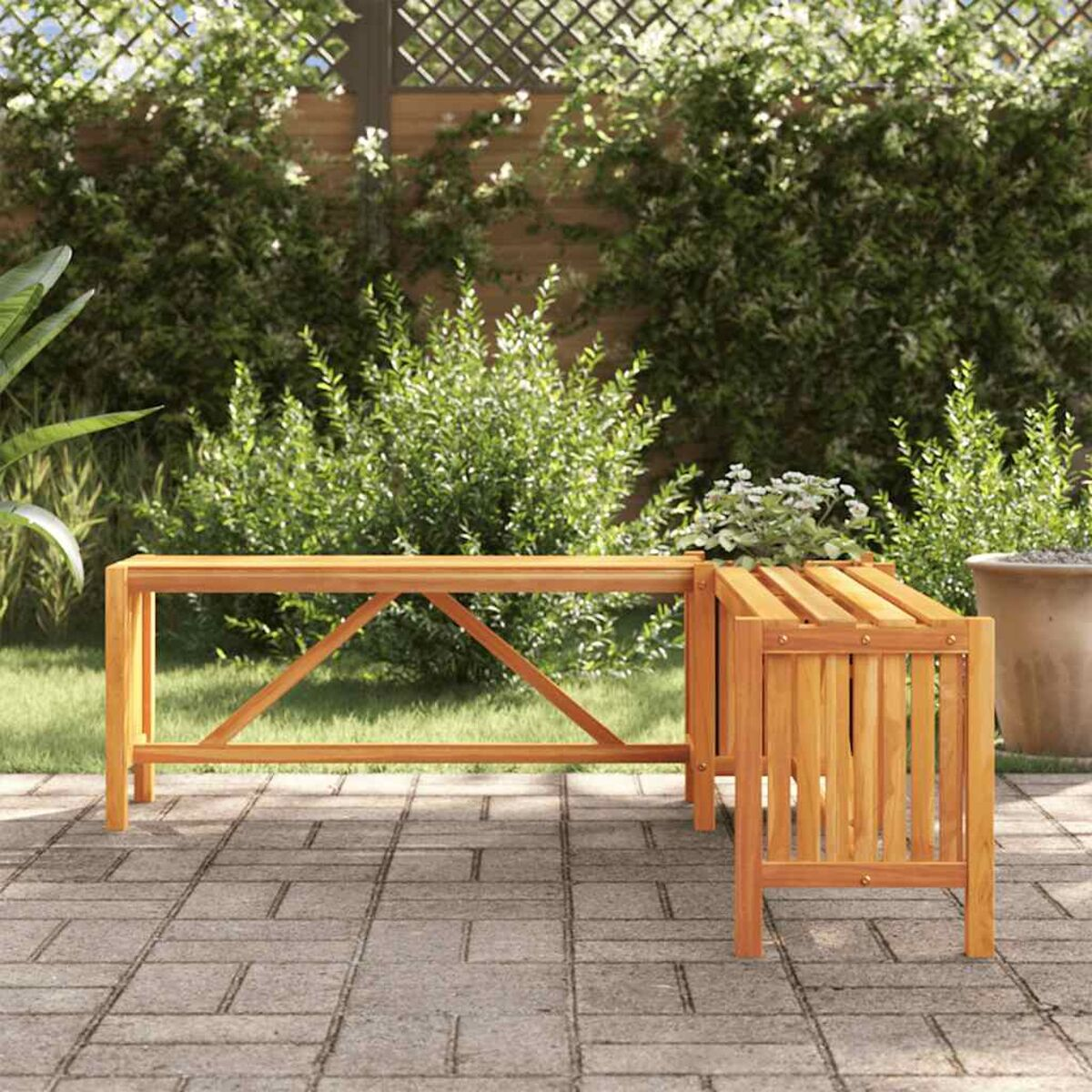 Holzbank mit Tisch. Im Garten mit Ziegelpflaster und viel Grün.