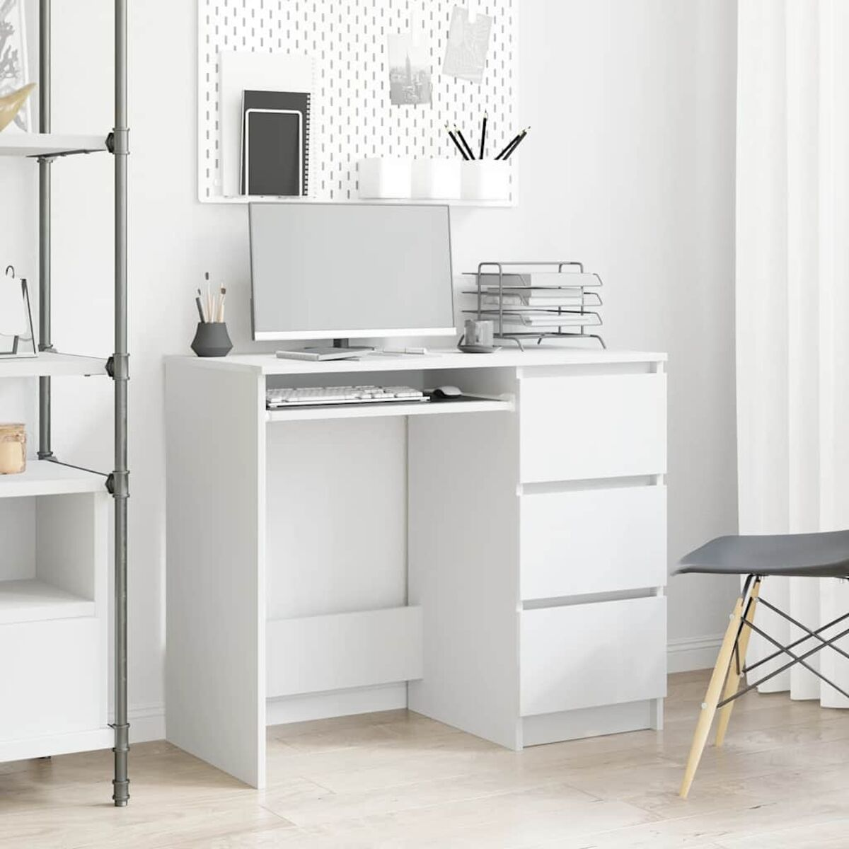 Weißer Schreibtisch mit Schubladen, Tastaturablage und Monitor. Eine Lochwand hängt dahinter.