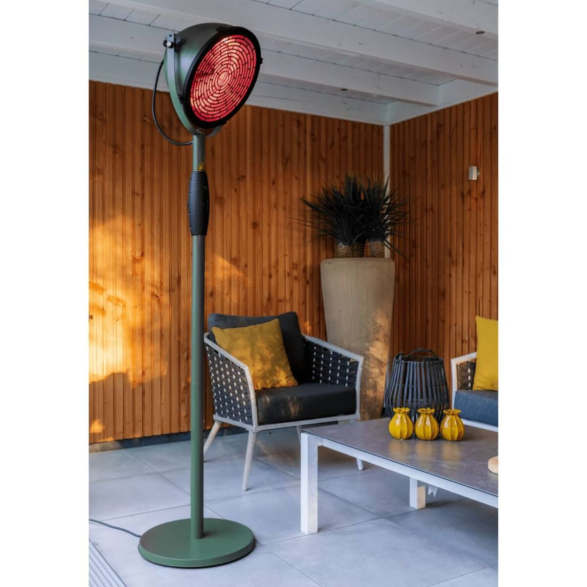 Buitenverwarming met rode gloed, op groene standaard, op terras.