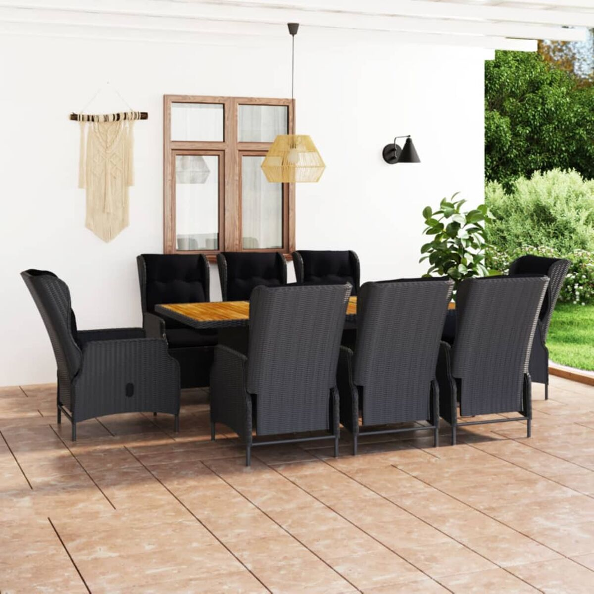 Ein Esszimmer-Set für die Terrasse mit Tisch und Stühlen. Eine Wand mit Dekoration und Pflanzen dahinter.