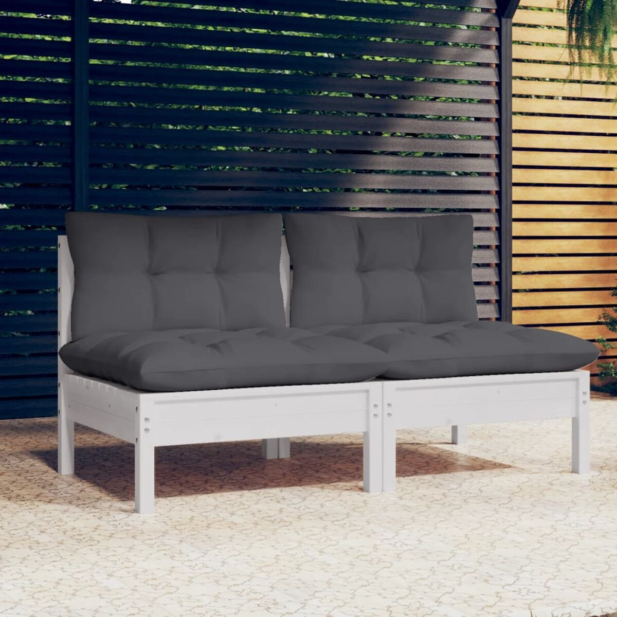 Zwei weiße Sofas für den Außenbereich mit dunkelgrauen Kissen. Sie stehen auf einer Steinplatte.