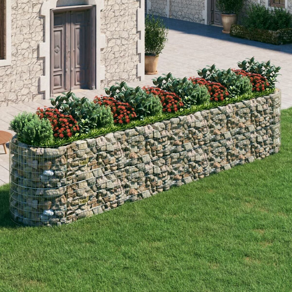 Steingabionen-Pflanzgefäß mit Pflanzen und Blumen. Grüner Gras-Hintergrund.