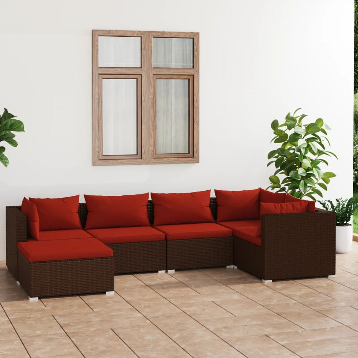 Braunes Outdoor-Ecksofa mit roten Kissen auf gefliestem Patio, in der Nähe eines Fensters und Topfpflanze.