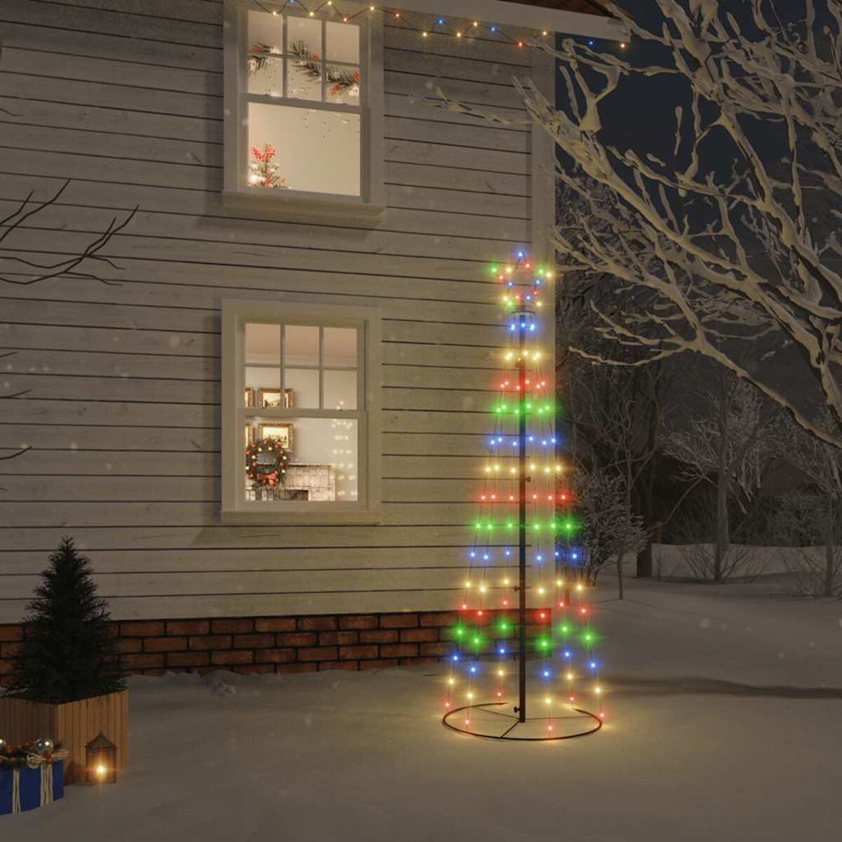 Weihnachtsbaum aus Lichtern im Freien. Haus im Hintergrund, Schnee am Boden. Festliche Urlaubsszene.