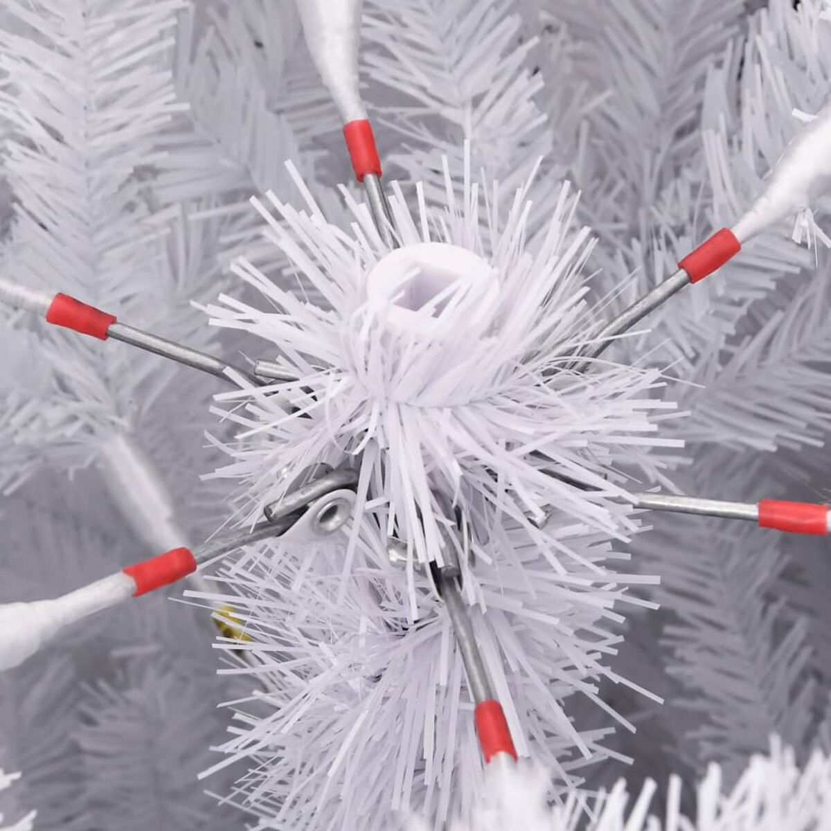 Weiße Weihnachtsbaumdekoration mit roten Spitzen an den Zweigen.