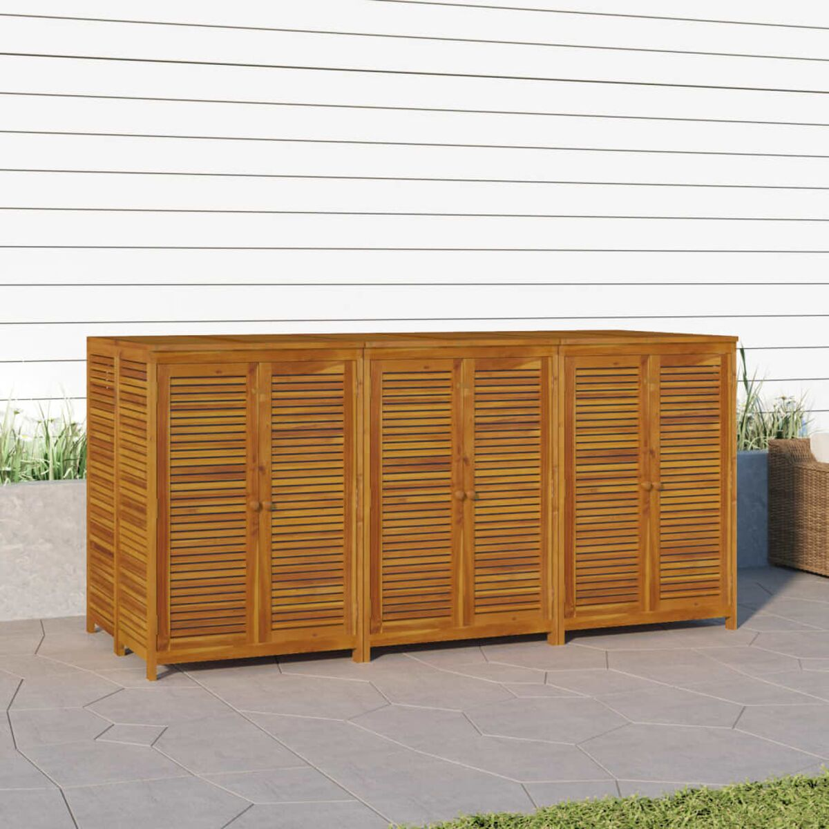 Holz-Außenaufbewahrungsschrank. Er hat drei Türen mit horizontalen Lamellen. Steht auf einer Terrasse.