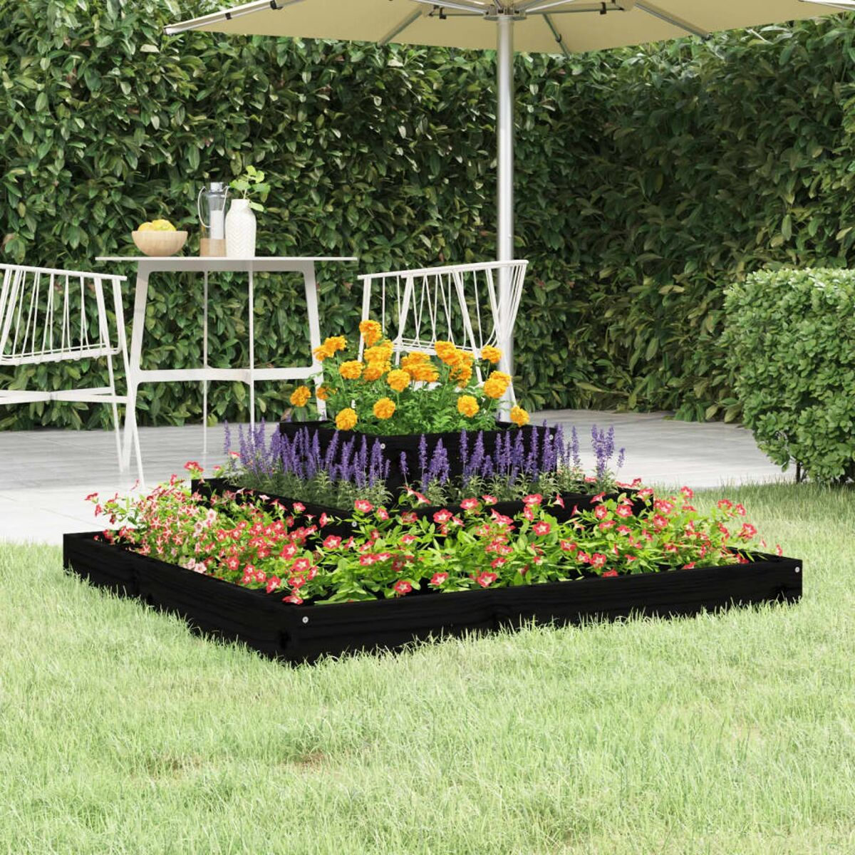 Garten im Freien mit abgestuften schwarzen Holzpflanzkästen, gefüllt mit bunten Blumen und einem Schirm.