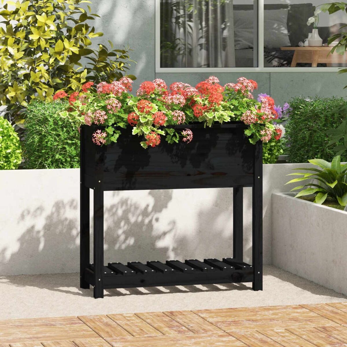 Schwarzer Holzpflanzer mit Blumen. Es ist auf einer Terrasse.