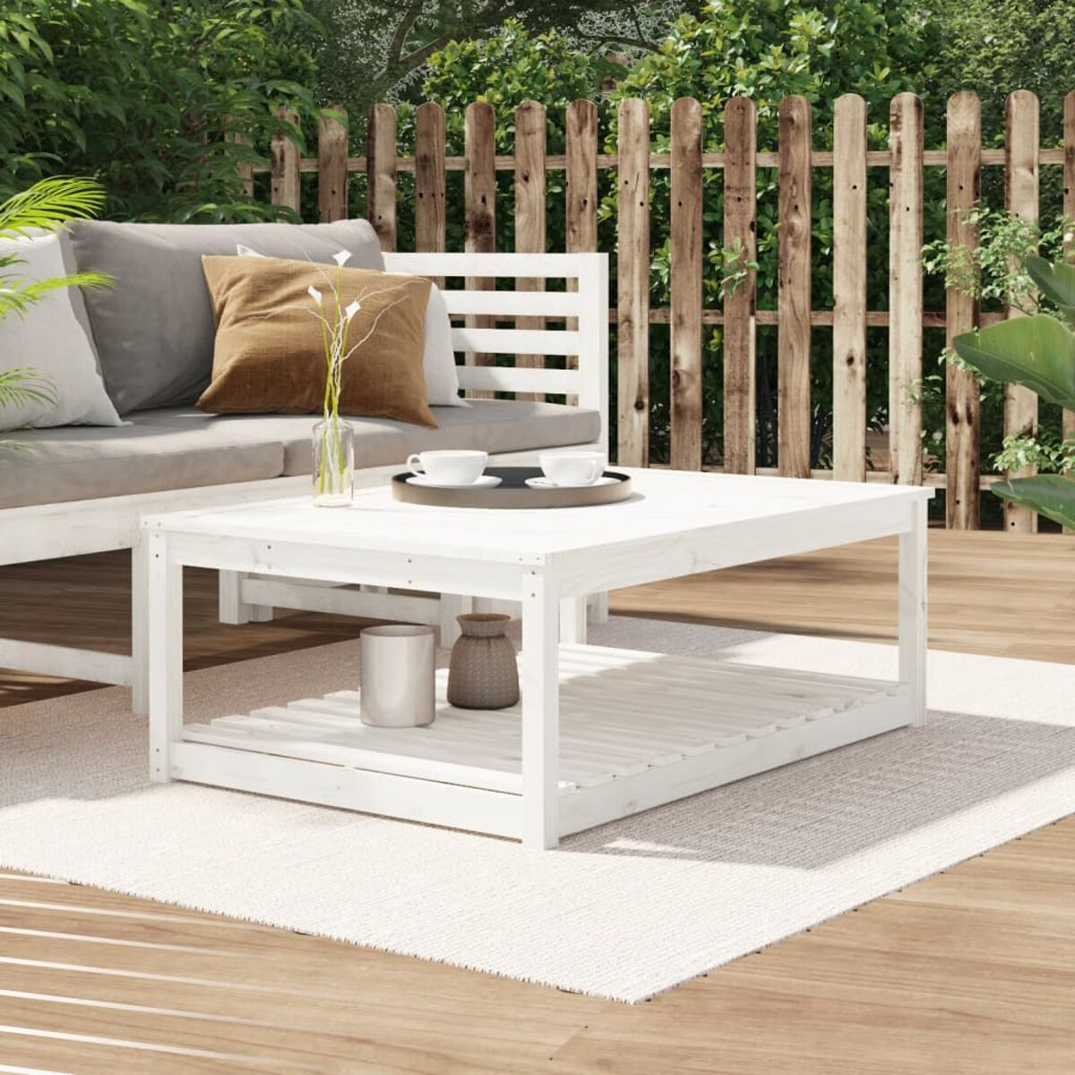 Weißer Holztisch mit unterem Regal, auf neutralem Teppich, im Freien.