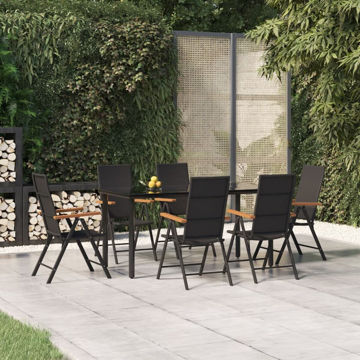 Essgruppe im Freien auf der Terrasse. Schwarzer Tisch und Stühle. Grünes Laub im Hintergrund. Schwarz und Braun.