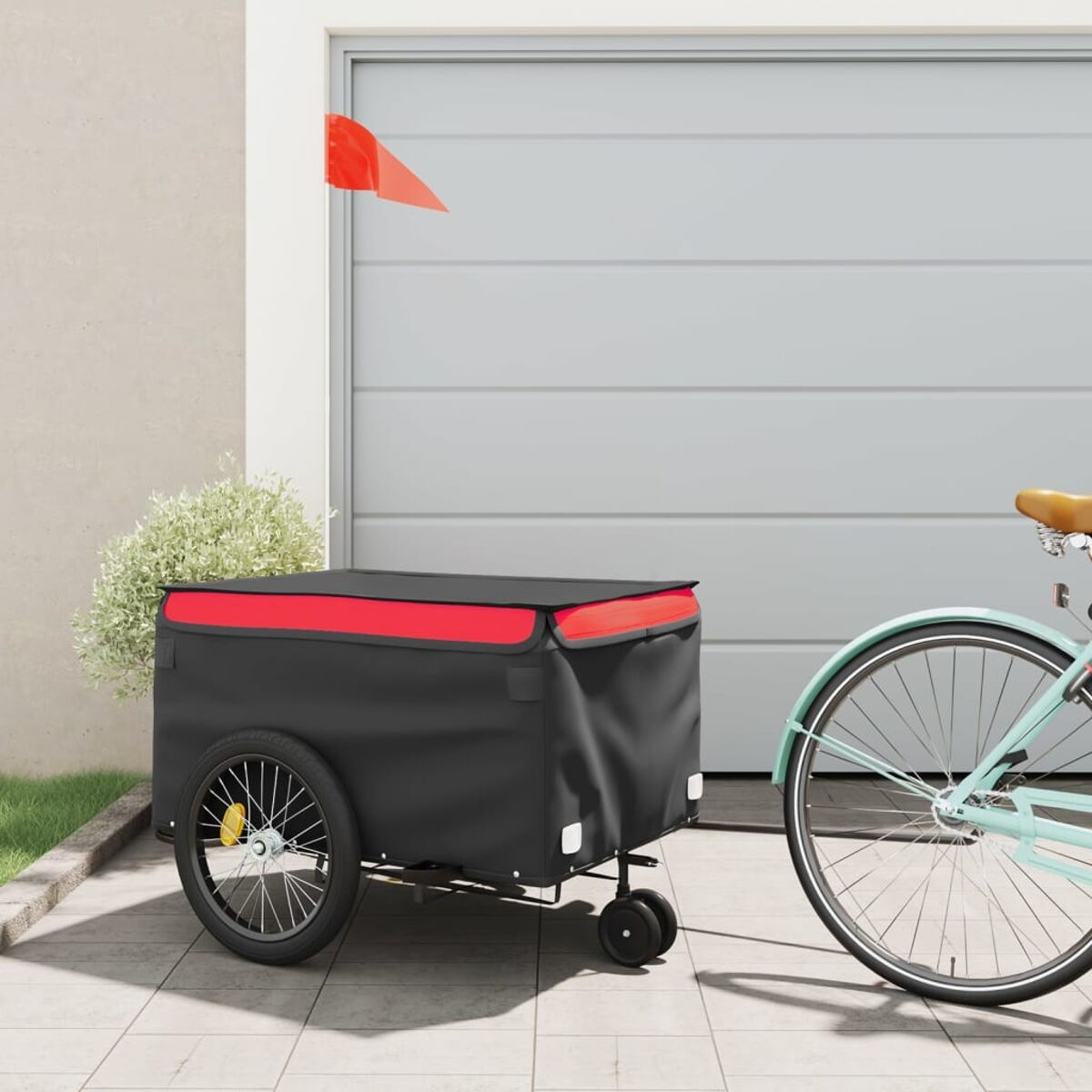 Schwarzer und roter Wagen an einem mintgrünen Fahrrad befestigt. Rote Flagge sichtbar. Hintergrund: Garagentor.