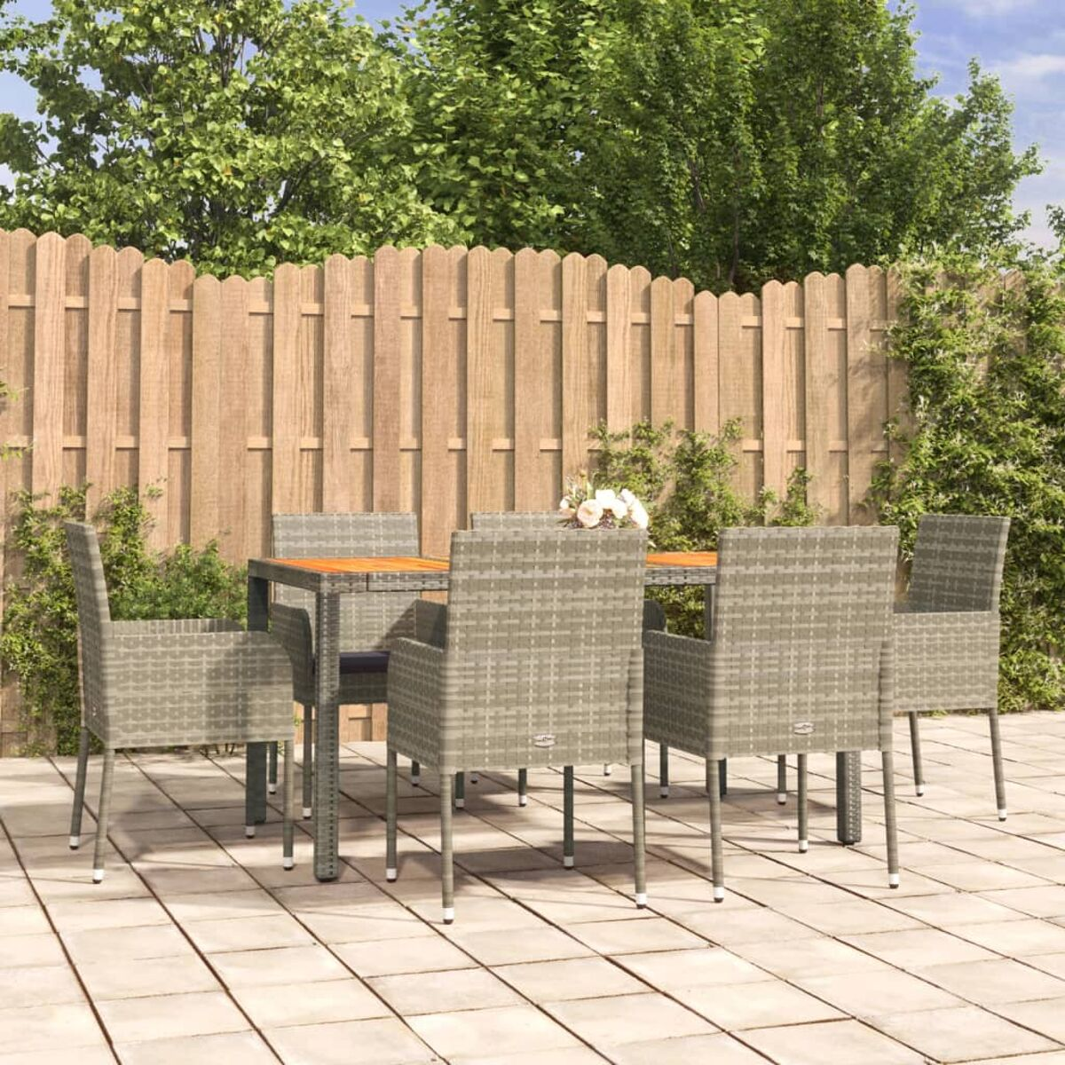 Essgruppe für den Außenbereich mit grauen Stühlen und einem Holztisch auf einer Terrasse.