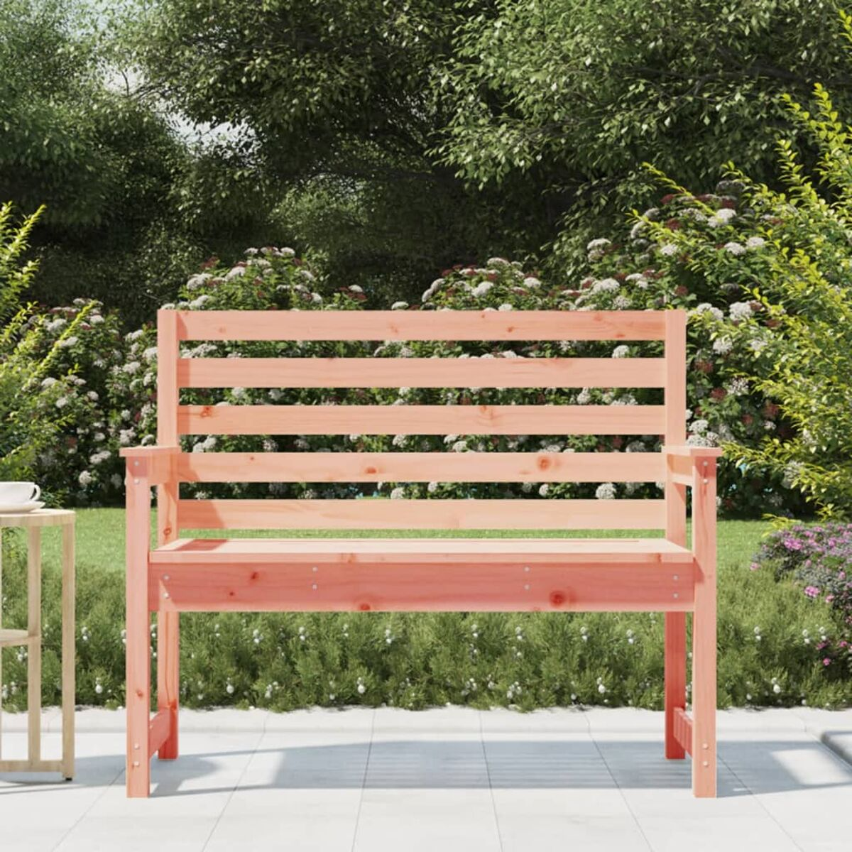 Holzbank auf der Terrasse mit Gartenhintergrund. Die Bank ist aus hellem Holz gefertigt.