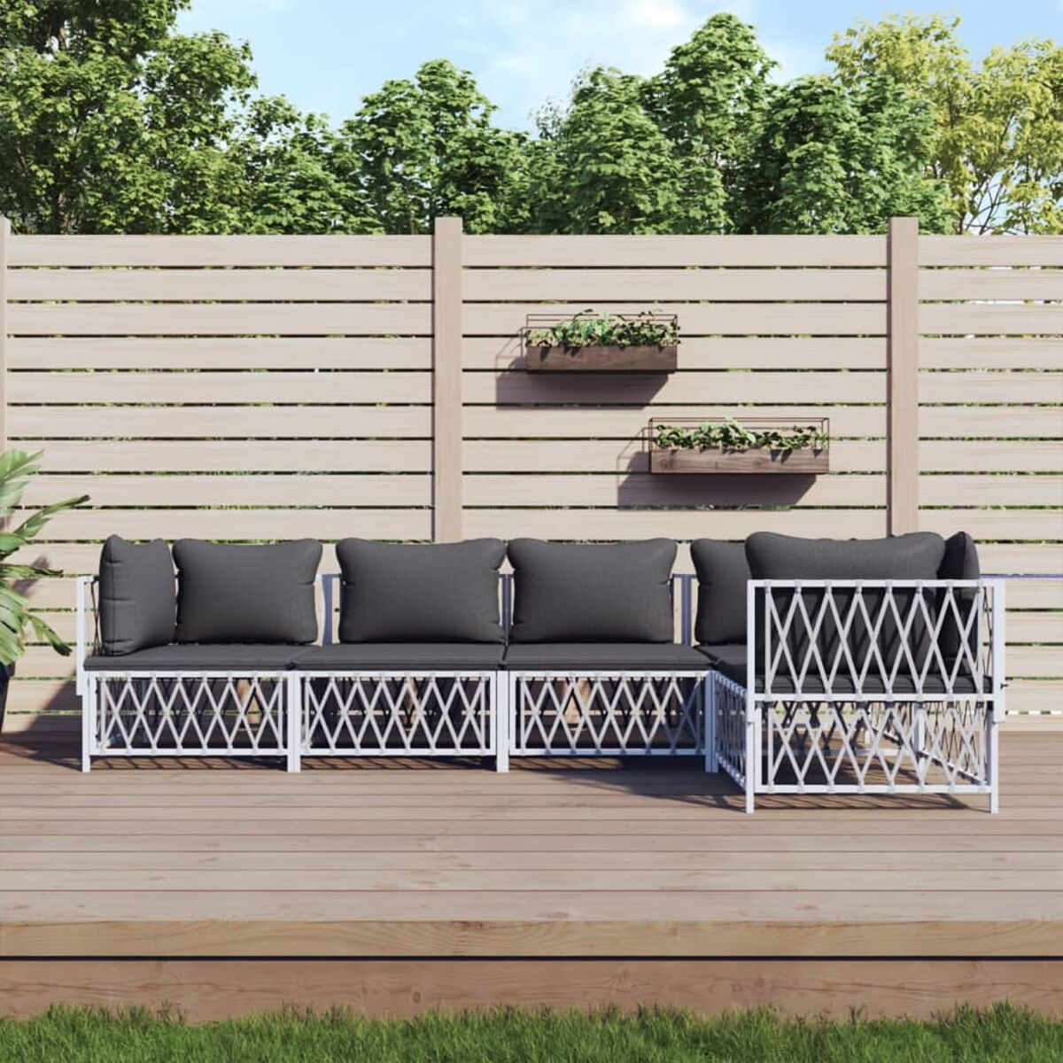 Weißes Gartenmöbel-Set mit dunkelgrauen Kissen. Holzterrasse, Zaun, Pflanzen.