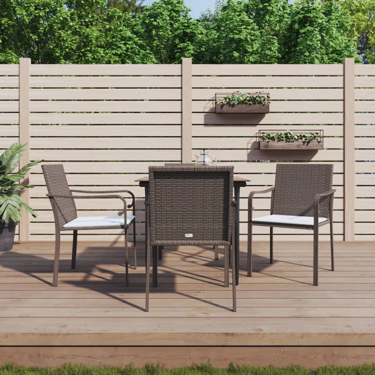 Essgruppe für den Außenbereich mit vier Stühlen und einem Tisch. Die Stühle sind gewebt und haben weiße Kissen.