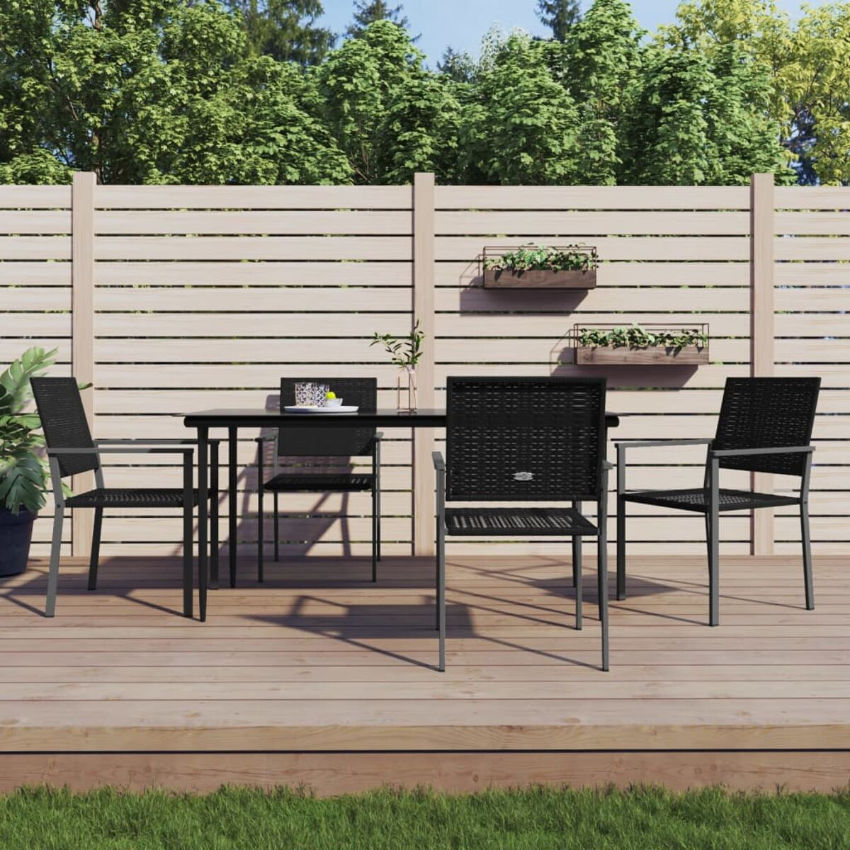 Essgruppe im Freien: schwarzer Tisch und Stühle auf Holzterrasse.
