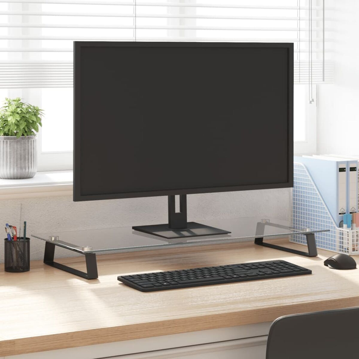 Computermonitor auf einem Schreibtisch. Schwarzer Bildschirm, Tastatur und Zubehör. Glasregal, helle Holzoberfläche.