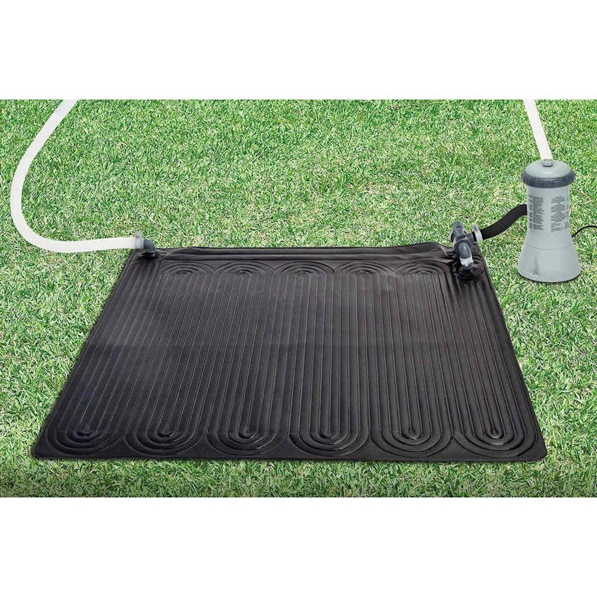 Schwarze Solar-Poolheizung auf grünem Gras. Weißer Schlauch verbindet sich mit einem Filtersystem.