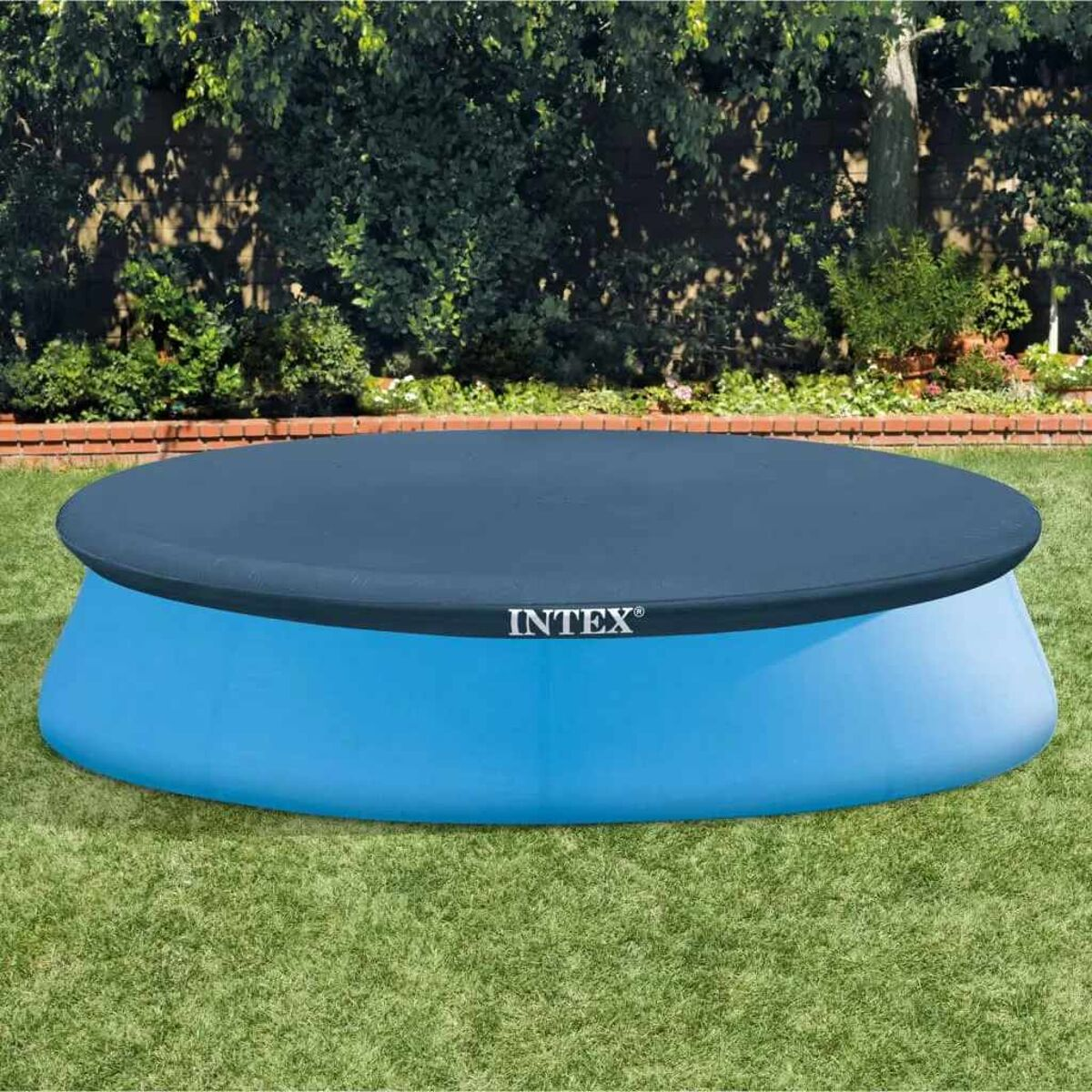 Blaue Intex-Poolabdeckung auf einem grünen Rasen. Die Abdeckung liegt über dem Pool.