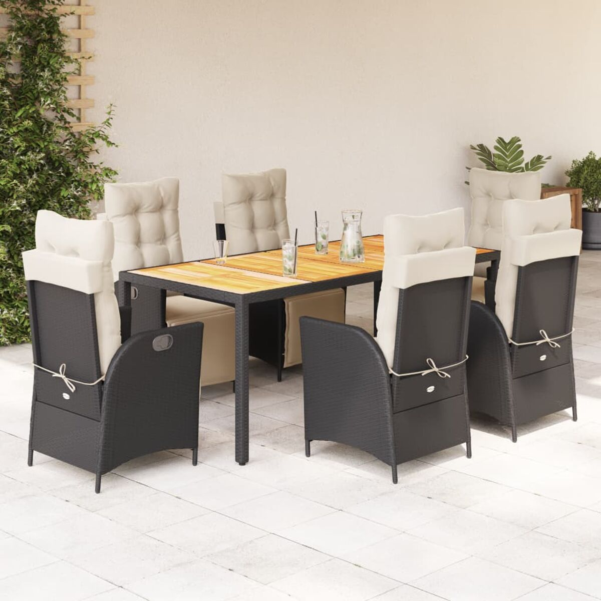 Essgruppe im Freien mit Tisch, Stühlen und Pflanzen. Der Hintergrund ist eine weiße Wand.