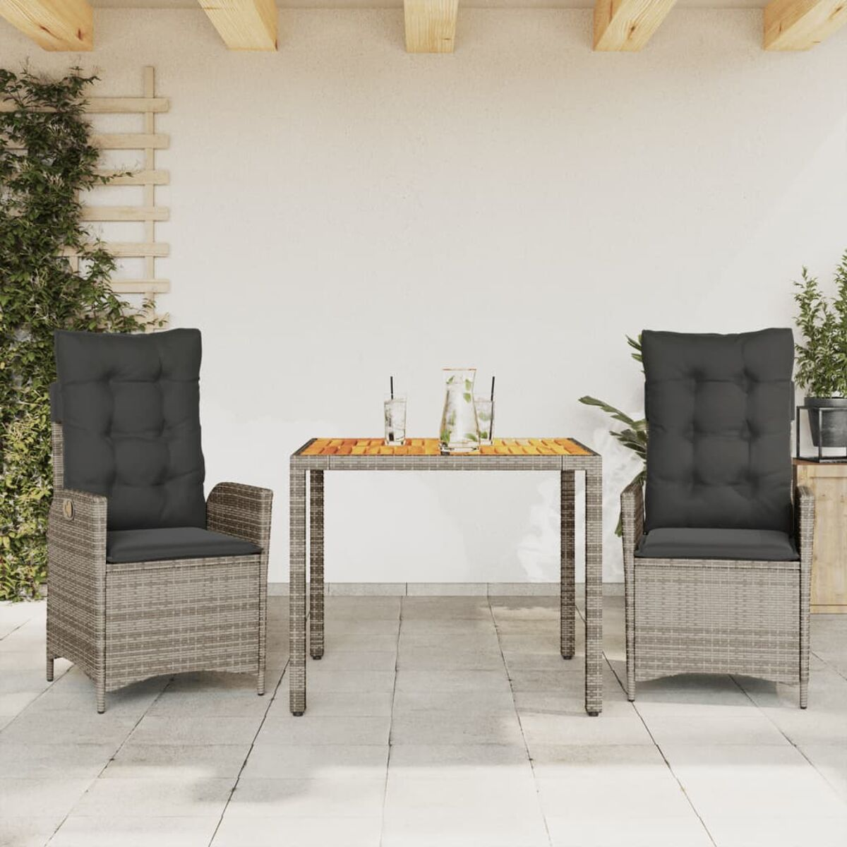 Rattan-Gartenmöbel mit zwei Stühlen, einem Tisch und Dekorationen.