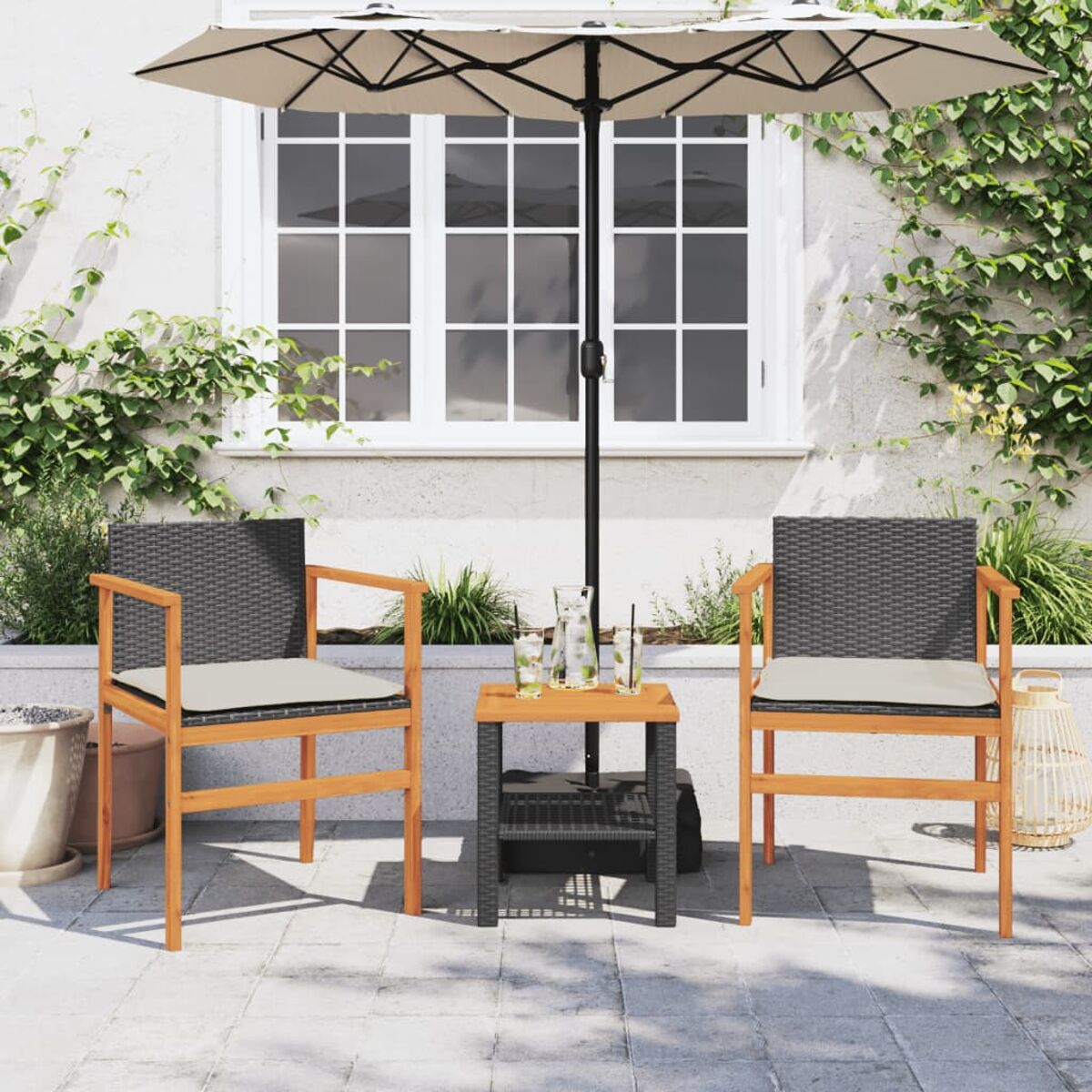 Terrassenset mit Stühlen, Tisch und Sonnenschirm auf Steinterrasse, Pflanzen und Wand.