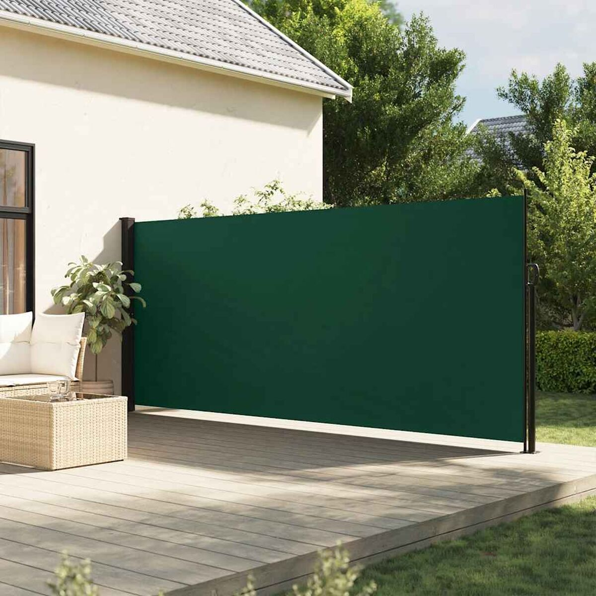 Grüner Outdoor-Sichtschutz auf einem Holzdeck in der Nähe eines Hauses, der Privatsphäre schafft.
