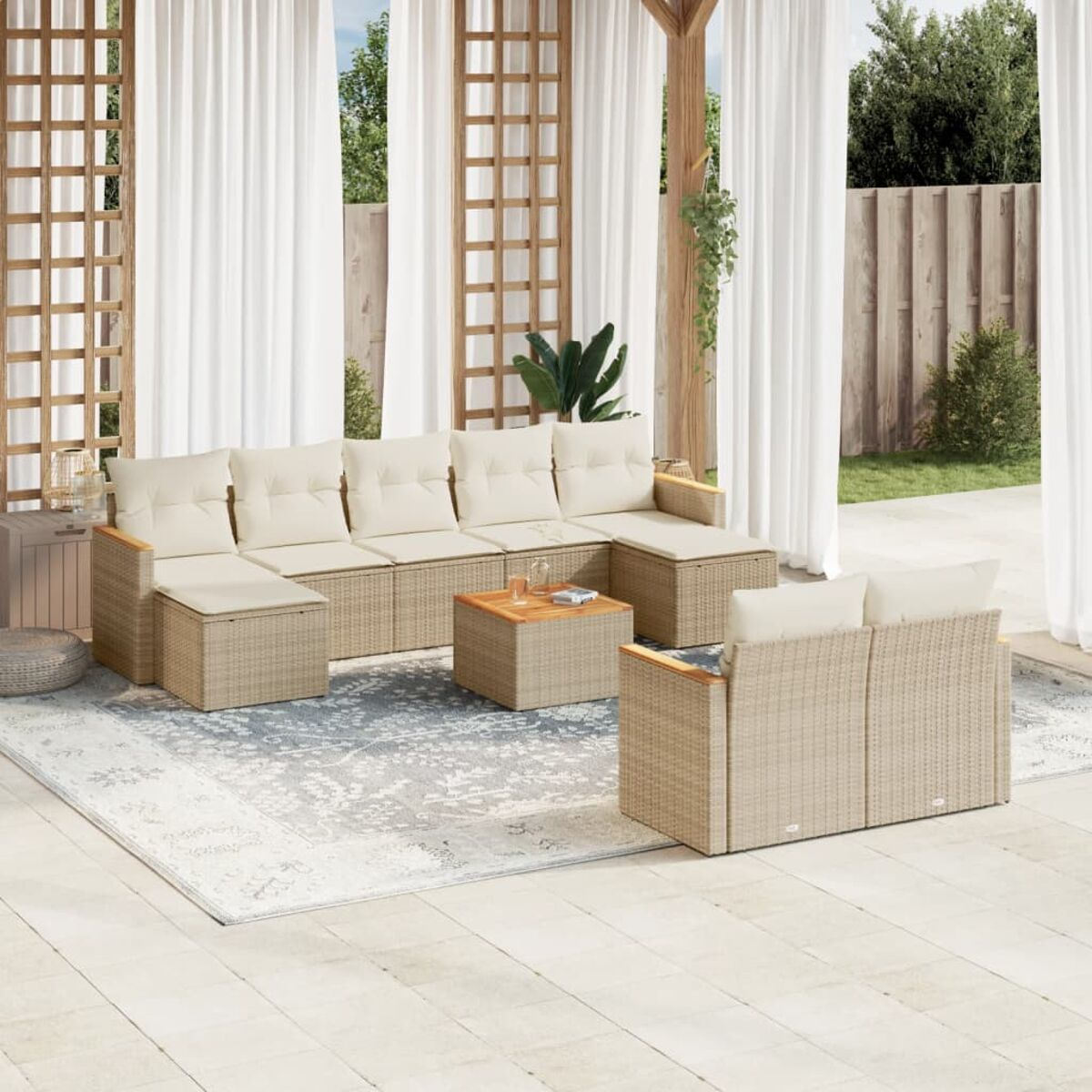 Beiges Outdoor-Ecksofa aus Rattan mit Kissen auf einem Teppich. Weiße Vorhänge im Hintergrund.