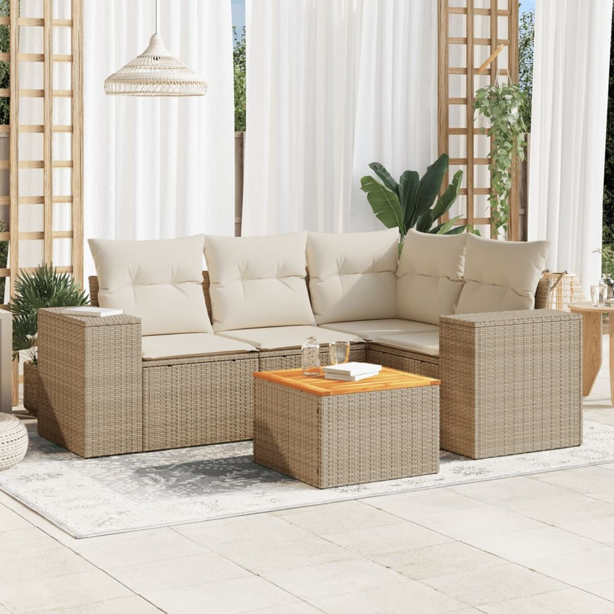 Geflochtenes Sofaset mit beigen Kissen, einem Holztisch und einer gewebten Pendelleuchte. Die Szene ist eine Außenterrasse.