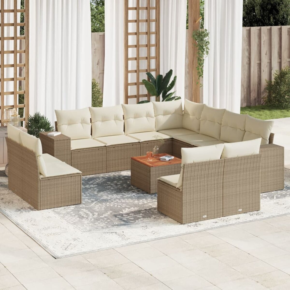 Gartenmöbel-Set aus Korbgeflecht mit beigen Kissen, Teppich und Holztisch, Vorhängen und Pflanzen.