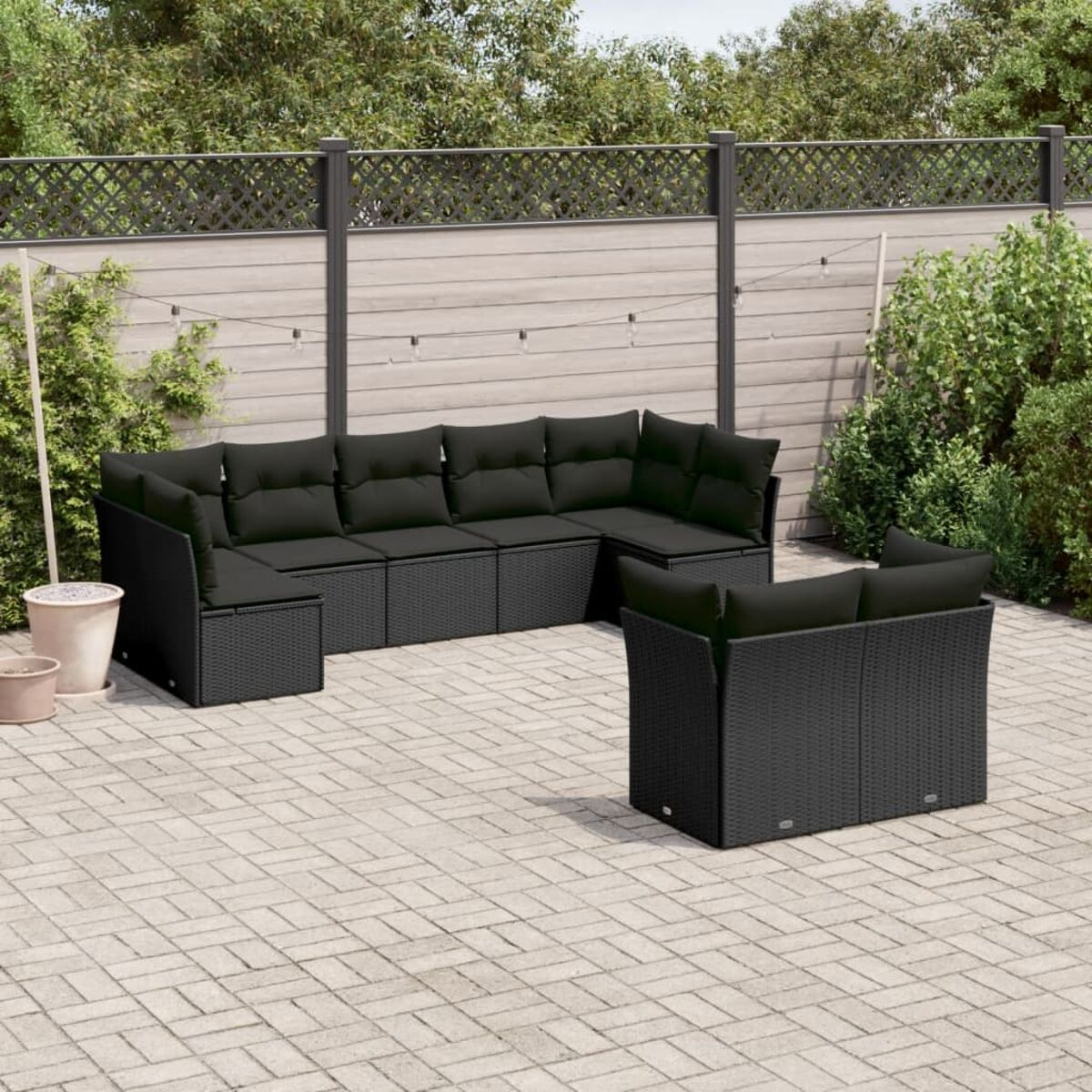 Outdoor-Sitzgruppe in Schwarz, mit Backstein-Patio und Grün.