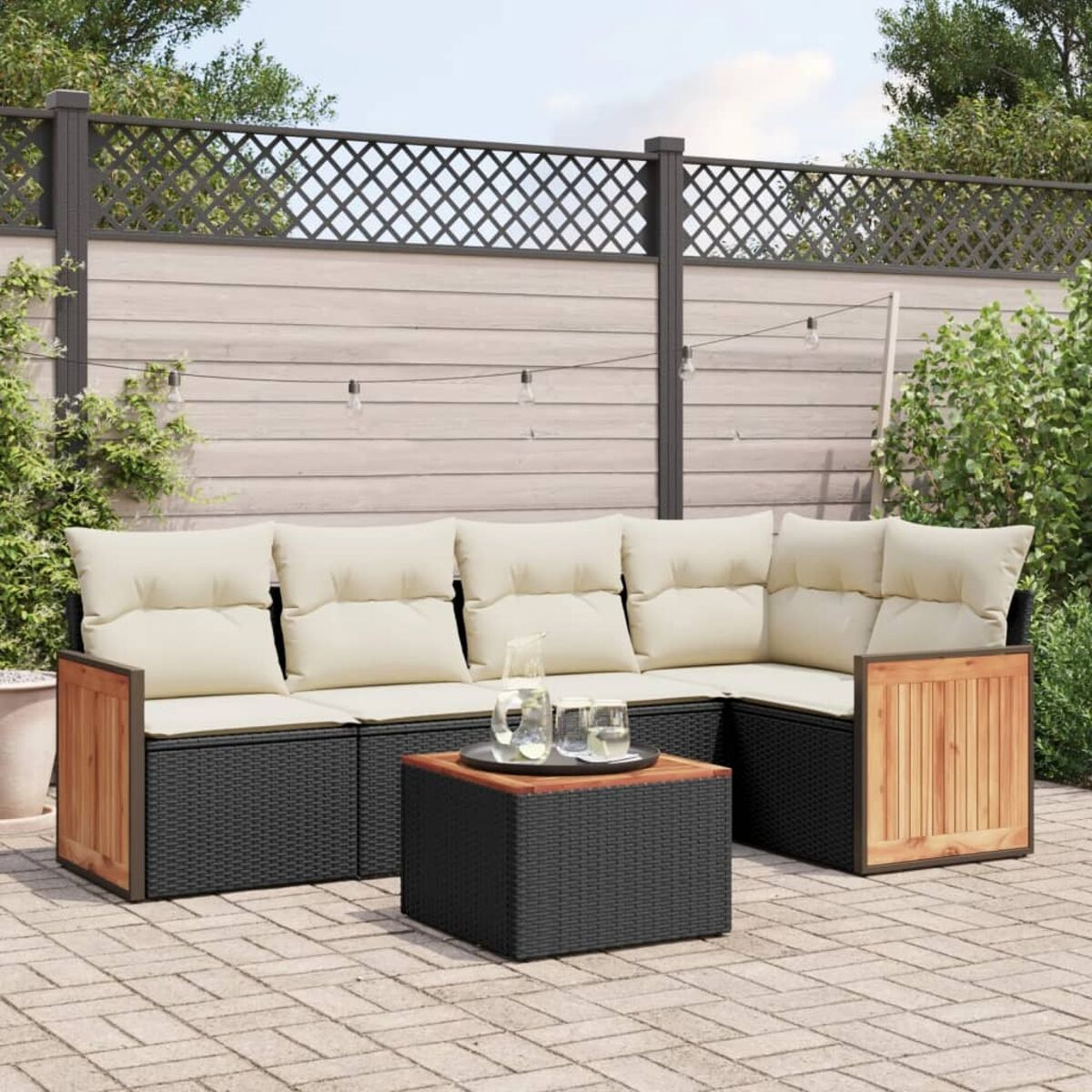 Gartensofa mit cremefarbenen Kissen, Holzakzenten und einem schwarzen Tisch.
