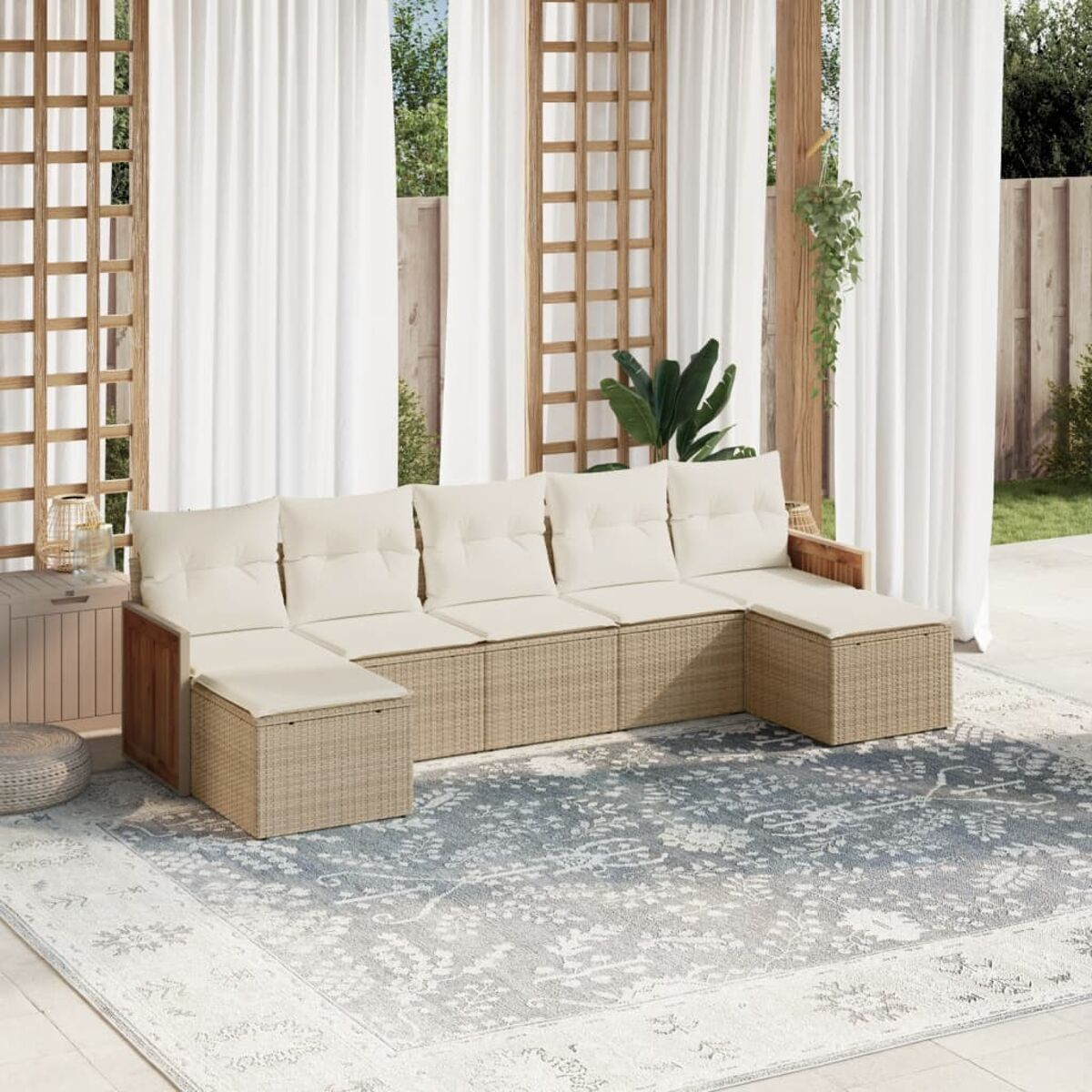 Geflochtenes Ecksofa mit beigen Kissen. Außenbereich mit Vorhängen und einem Teppich. Holzrahmen.