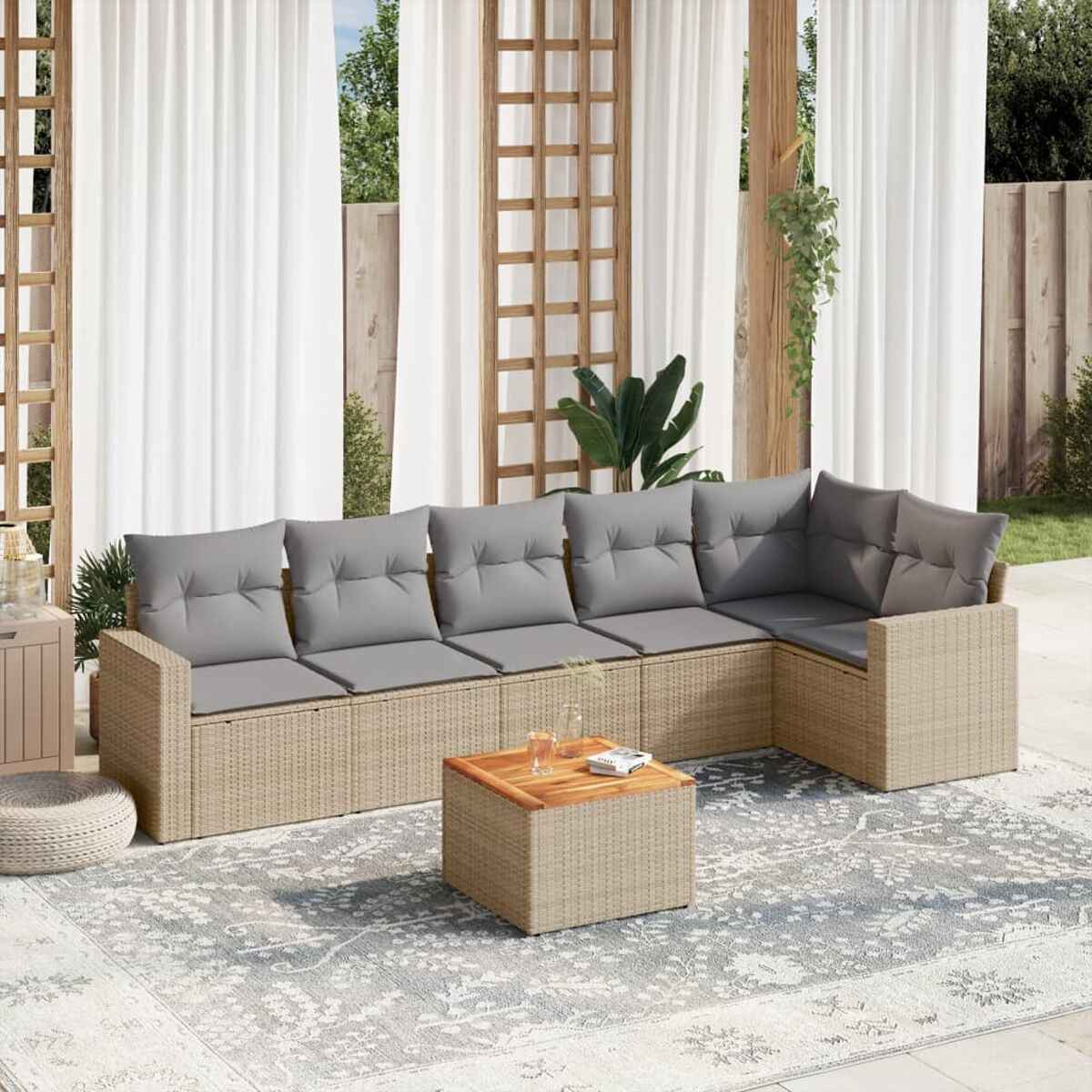 Beiges Outdoor-Ecksofa mit grauen Kissen, Couchtisch und einem Teppich.