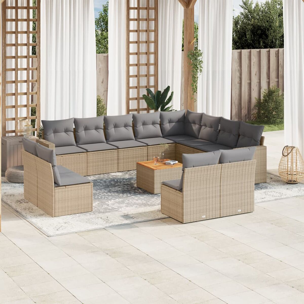 Terrassenszene mit beigen Rattanmöbeln und grauen Kissen, Vorhängen und Teppich.