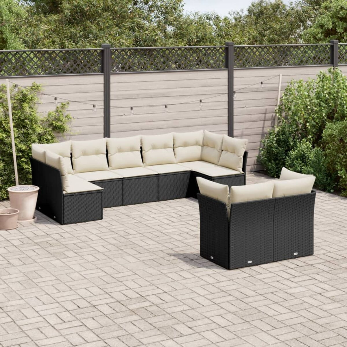 Ein großes Outdoor-Ecksofa-Set mit cremefarbenen Kissen auf einer Ziegelterrasse.