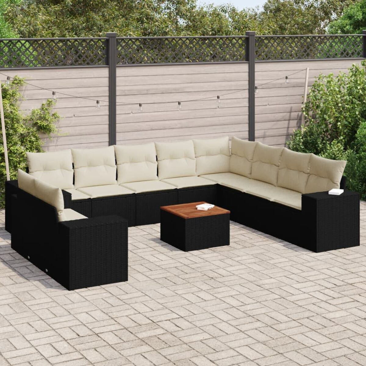 Outdoor-Sitzgruppe, schwarzes Korbgeflecht, beige Kissen, kleiner Tisch.
